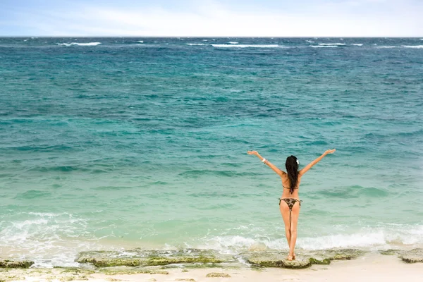 Girl standing on the beach and looking at sea — ストック写真