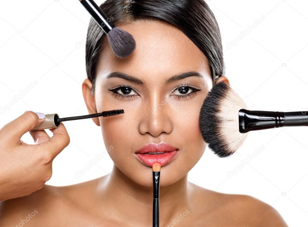beautiful woman with make-up brushes near face