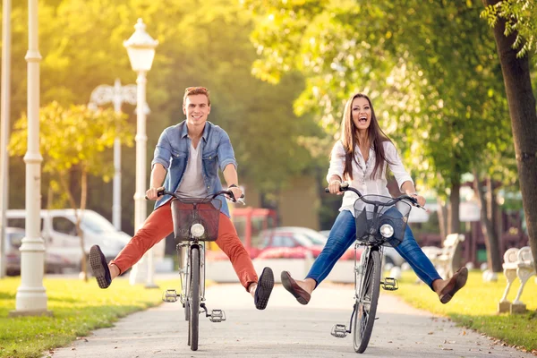 Feliz casal engraçado andando de bicicleta — Fotografia de Stock