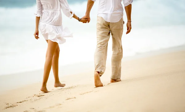 夫妇手牵着手在海滩上散步。 — 图库照片