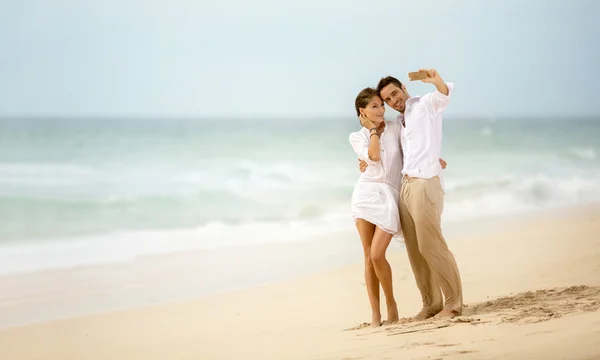 使用智能手机的拍照拍照的海滩度假夫妇 — 图库照片