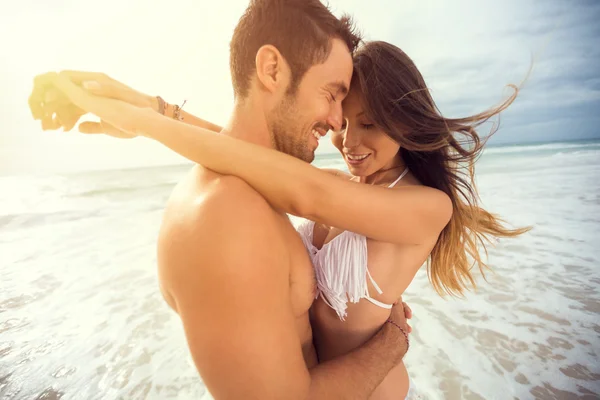 Νεαρό ζευγάρι χαρούμενος με επιστήσω την καρδιά σε τροπική παραλία — Φωτογραφία Αρχείου