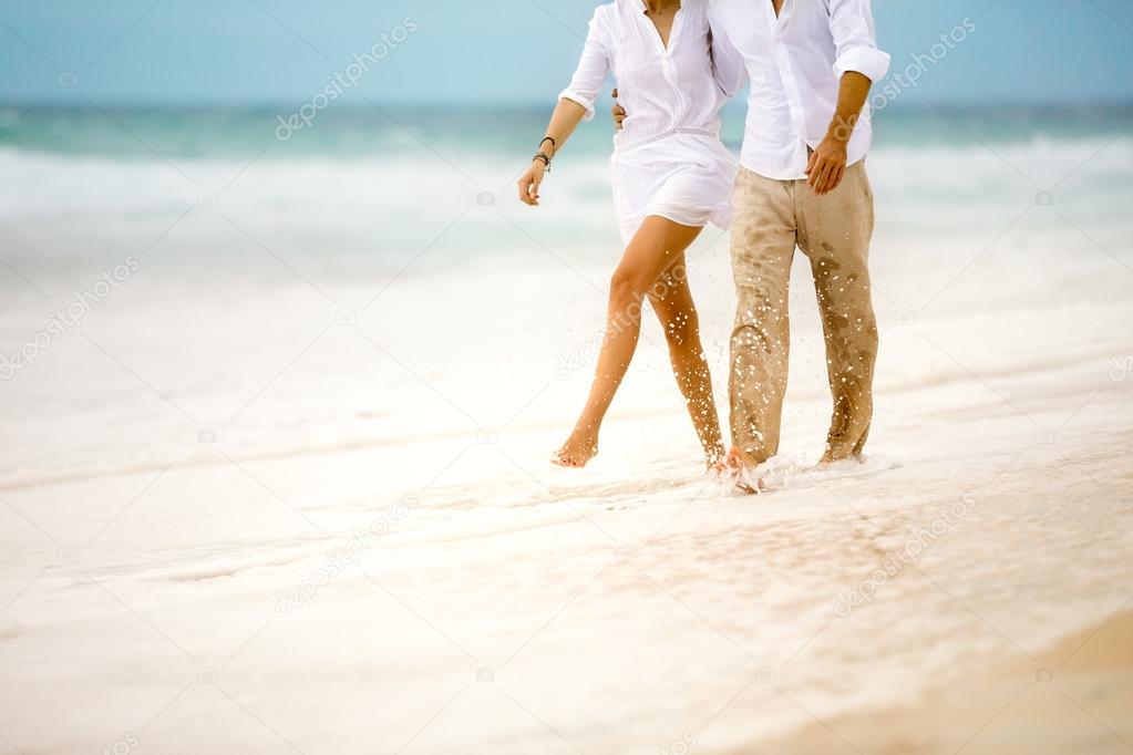 couple walking through the waves
