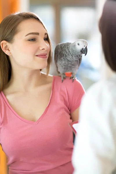 Young  satisfied girl listening diagnosis of veterinarian in vet — Stock Photo, Image