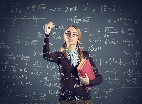 Student meisje formules schrijven op transparante muur — Stockfoto