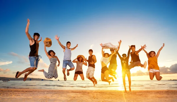 Grupo de amigos pulando na praia — Fotografia de Stock