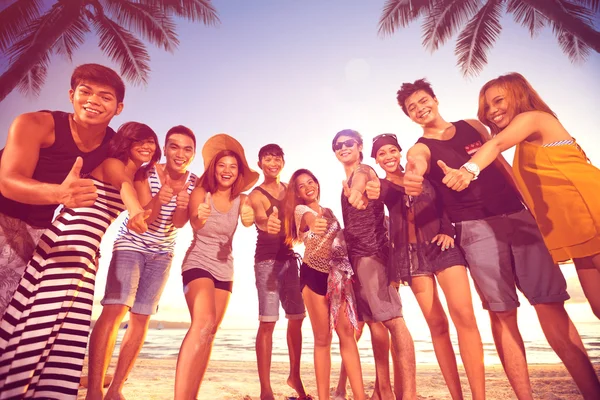 Groep van mannen en vrouwen duimen opdagen op strand glimlachen — Stockfoto