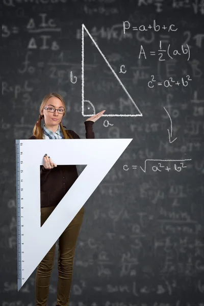 Estudante com uma régua grande e teorema de Pitágoras no quadro negro — Fotografia de Stock