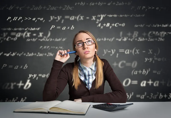 Ung student med tankeväckande uttryck sitter vid ett skrivbord — Stockfoto