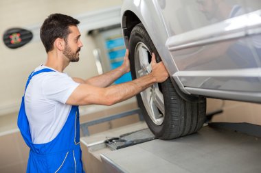 yakışıklı mekanik bir lastik değiştirme