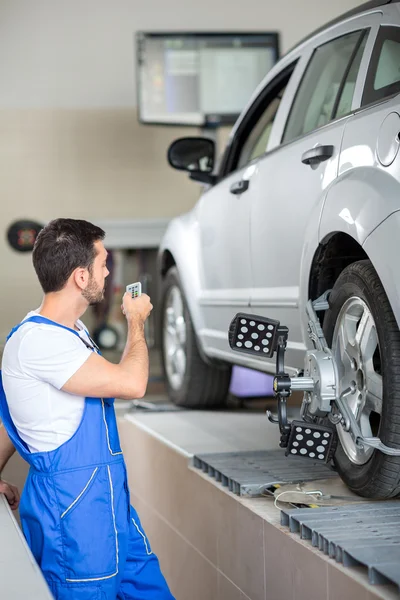 Young serviceman checking wheel — Stock Photo, Image