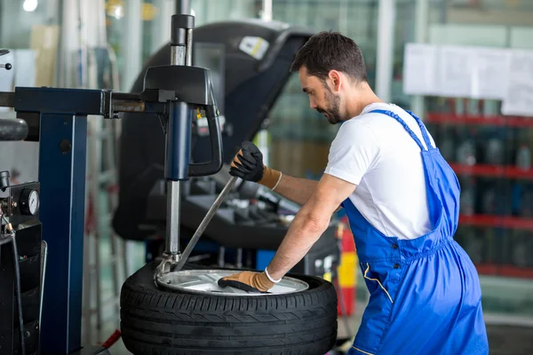 Mechanic replace tires on wheels — Stock Photo, Image