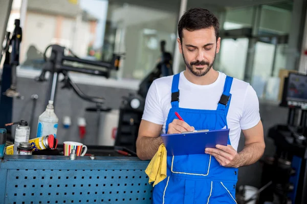 Monteur in auto reparatie winkel staande — Stockfoto