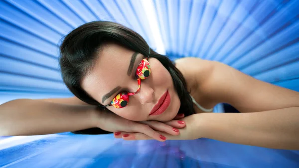 Girl with protect glasses in solarium — Stock Photo, Image