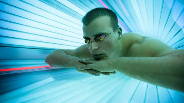 Mann bräunt sich im Solarium — Stockfoto