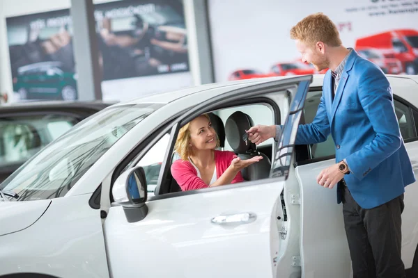 Gerente de vendas dando a chave do carro novo — Fotografia de Stock