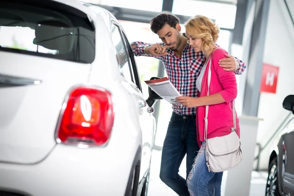 Casal feliz escolhe comprar um carro — Fotografia de Stock