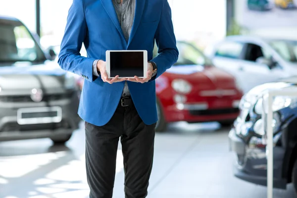 Bilen säljaren håller Tom pc tablet — Stockfoto