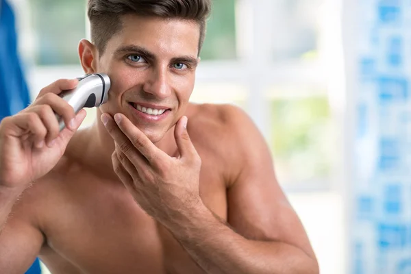 Man shaving face with electric razor — Stock Photo, Image