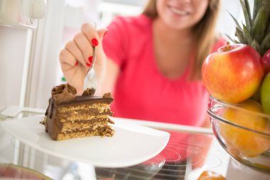 Tasty piece of chocolate cake attracts girl to eat it clipart