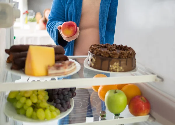 Człowiek na dietę wziąć zdrowy jabłko zamiast twardego żywności — Zdjęcie stockowe