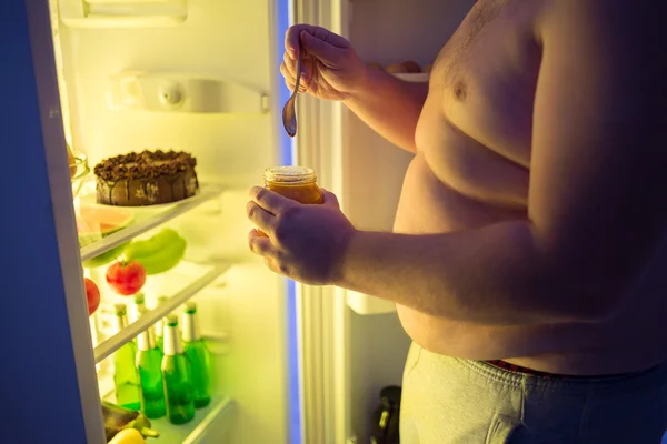 Primo piano di grasso uomo rompere la dieta di notte e mangiare dolce malsano — Foto Stock