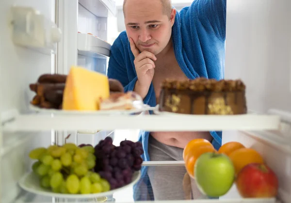 El hombre corpulento desea comida dura en lugar de comida saludable — Foto de Stock