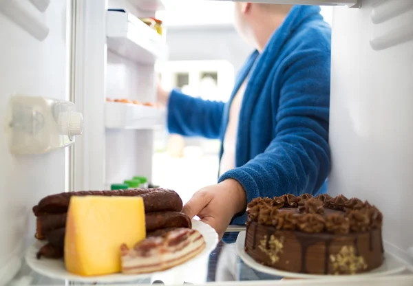 Übergewichtige nehmen Wurst und Käse aus Kühlschrank — Stockfoto
