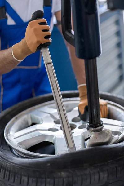 Reparaturfirma mit Installateur ersetzt Reifen am Rad — Stockfoto