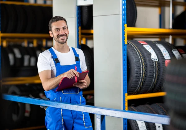 Mechanik v modré uniformě drží schránky — Stock fotografie