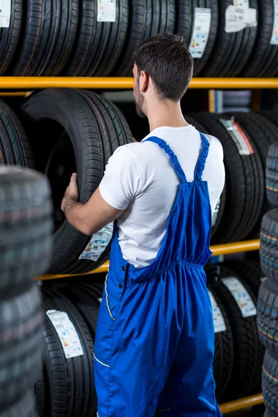 Mecânico verificar um pneu novo para o carro — Fotografia de Stock