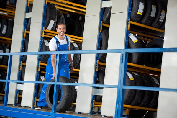 Mecánico de automóviles sonriente ha vendido un neumático de coche —  Fotos de Stock