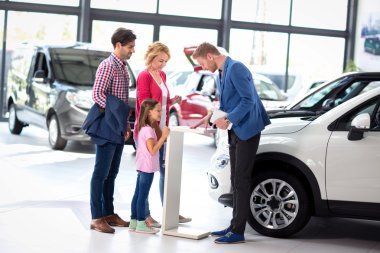Young  family listens carefully car dealers clipart
