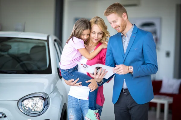 Autohändler zeigt Broschüre junge Frau mit Kind — Stockfoto