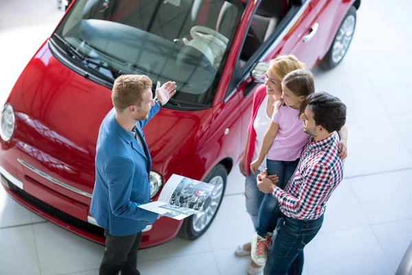 Young family in  the car dealership  saloon — Stock Photo, Image