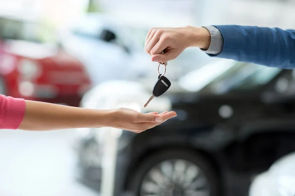 Car dealer giving keys to woman — Stock Photo, Image