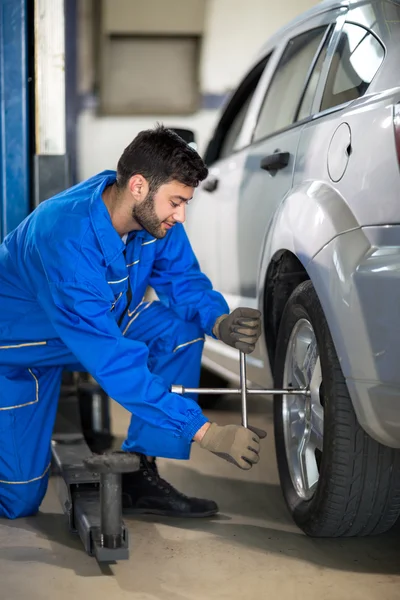 Uniform mechanic working on tyre — Stock Photo, Image