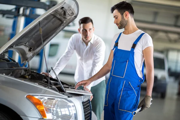 Cliente y empleado buscando diagnóstico en el motor — Foto de Stock