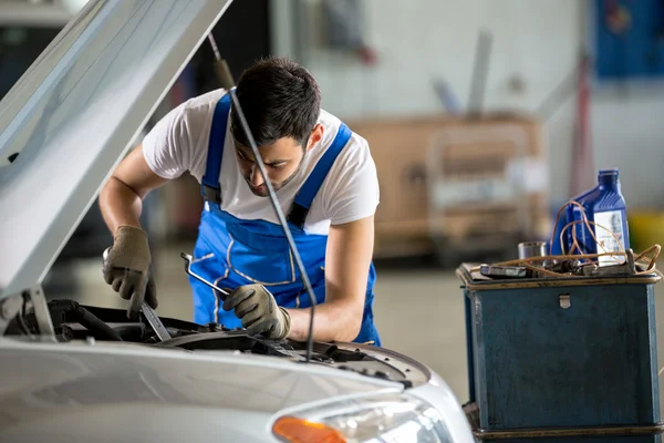 Mécanicien automobile travaillant sous le capot — Photo