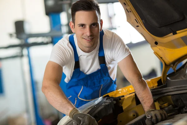 Lachende mechanic werken aan motor — Stockfoto