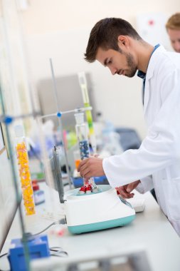 Kimya teknisyeni tüp shaker koymak.