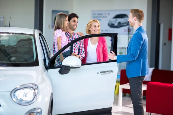 Familia alegre en sala de exposición de coches — Foto de Stock