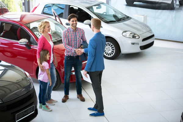 Vendedor de automóveis mostrando novo veículo para os clientes — Fotografia de Stock