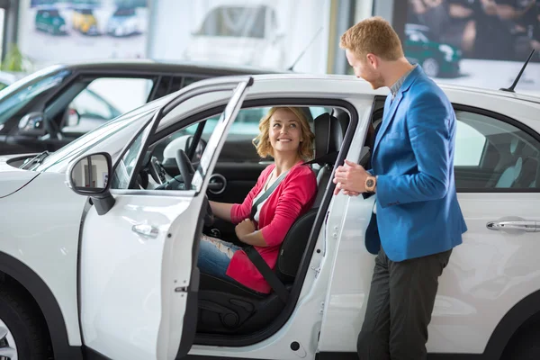 Feliz cliente feminino em um carro showroom — Fotografia de Stock