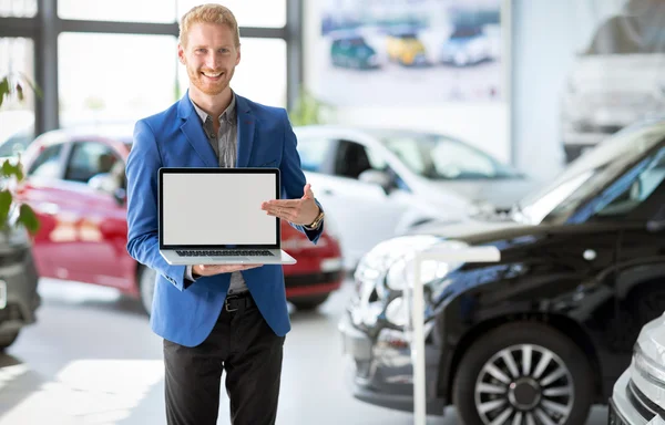 Vrolijke auto agent wijzen in de laptop — Stockfoto