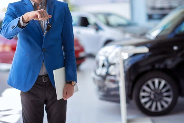 Автомобильный агент держит ключ от машины перед собой — стоковое фото