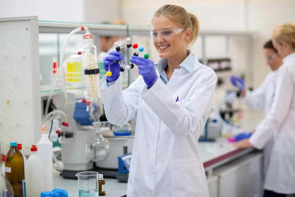 Fröhlicher Chemiker hält molekulares Modell im Labor — Stockfoto