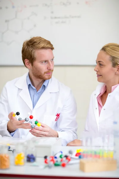 Chemieprofessor mit Molekularmodell und Assistenten in der Kl. — Stockfoto