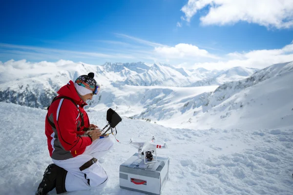 Engenheiro com controles remotos quadrocopter drone a as montanhas — Fotografia de Stock