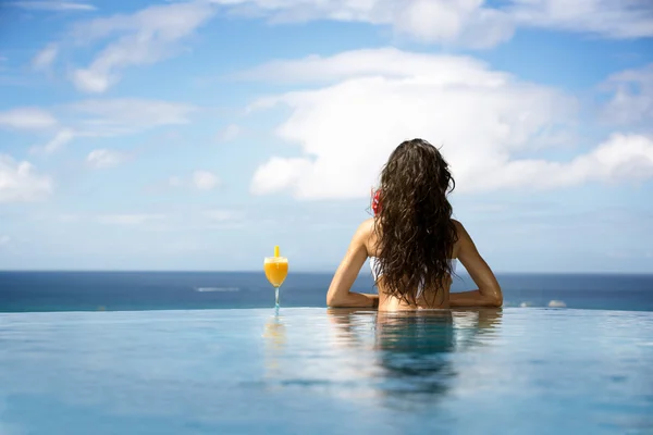 Kvinnan njuter cocktail i en pool — Stockfoto